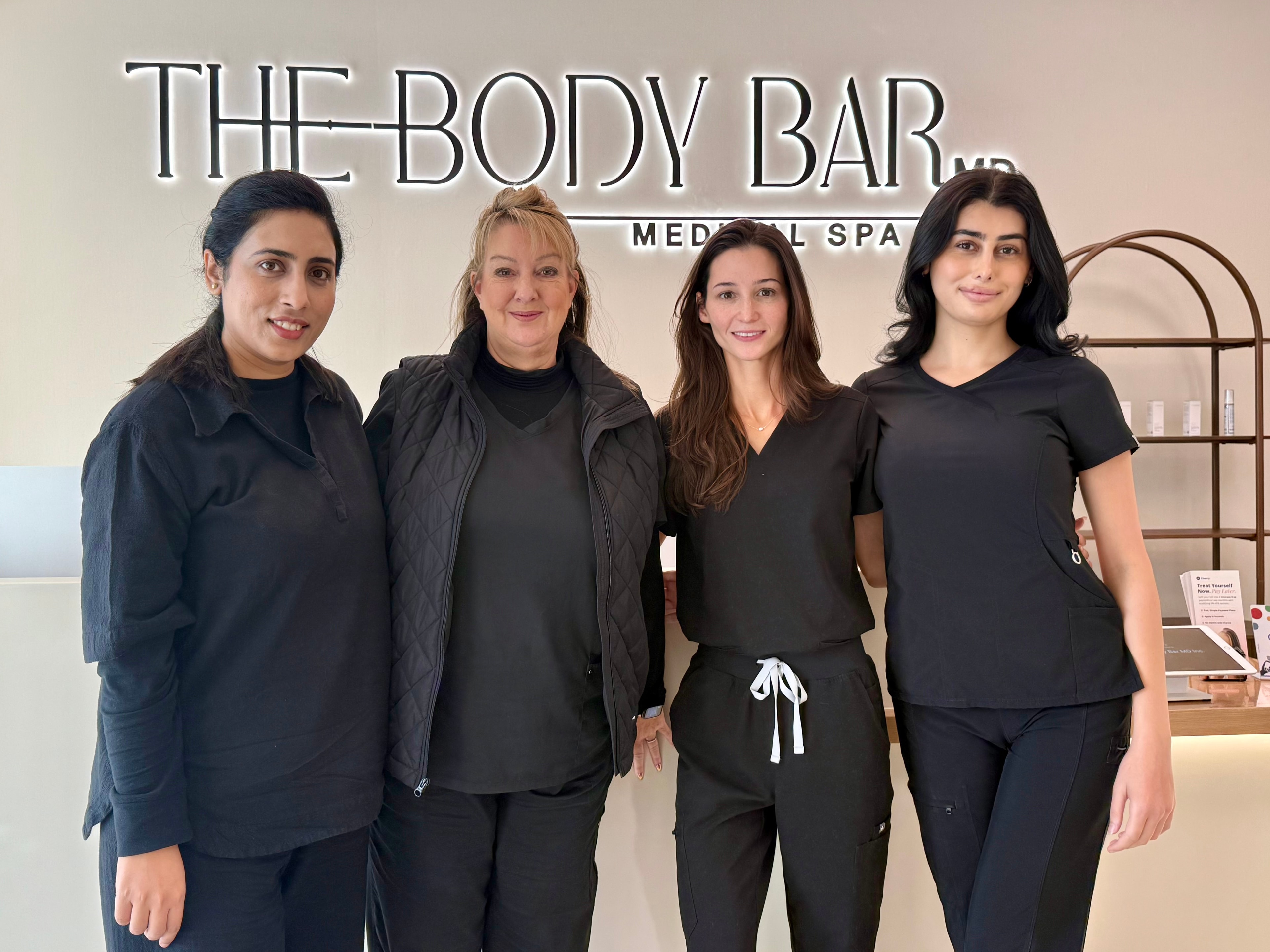The Body Bar MD team standing together at the reception of their Ellicott City clinic
